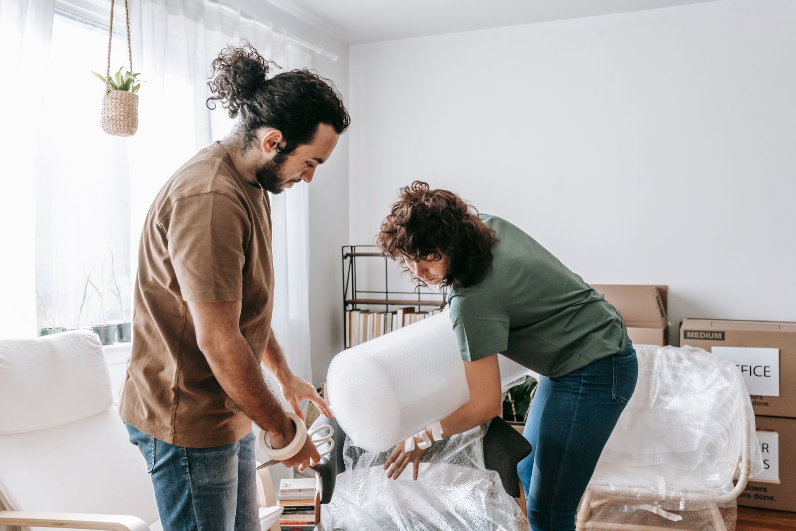 A family carrying moving boxes into their new home